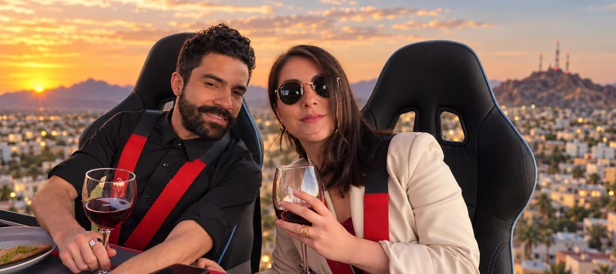 Pareja brindando con copas de vino tinto durante el vuelo de Dinner in the Sky, atardecer sobre Hermosillo